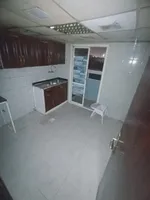 A happy room and a hall for annual rent in the Sanaiya area in Ajman, with multiple features such as a spacious hall, a modern design, 24-hour services and a vital area. We add central air conditioning, a kitchen with a balcony, and free parking, in  : Image 2