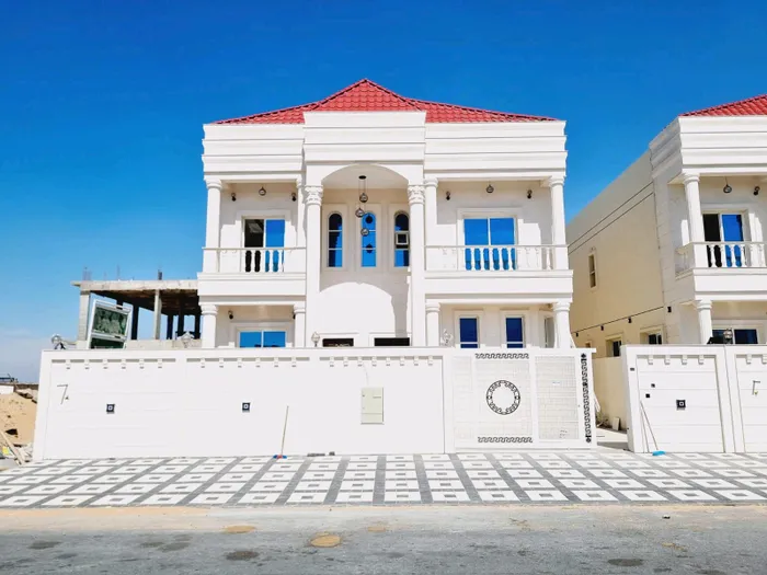 For sale, including registration and ownership fees, in Ajman, Al Aliyah area, two floors, stone face, central air conditioning, directly on Jar Street, with the possibility of easy bank financing, villas of different designs. : Image 1