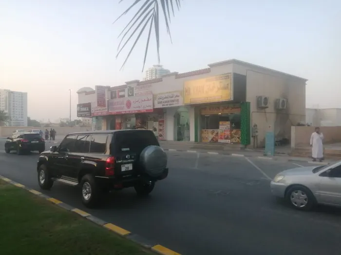 بناية محلات تجارية للبيع عجمان الراشدية 1 على شارع الشيخ راشد بن عبدالعزيز امام ابراج الفالكون زاوية على شارعين مساحة الارض 18222 الف قدم مربع  عدد المحلات 21 محل مواقف موقع مميز تملك حر جنب كل الخدمات السعر11 مليون : Image 1