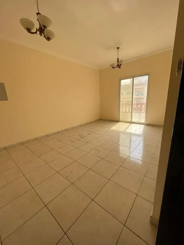 A spacious apartment with a balcony and a bathroom. The address is Al Nuaimah, close to King Faisal Street and Kuwait Street, Ali Mohammed bin Zayed Street, directly exit Dubai and Sharjah//Apartment with one bedroom, a living room, a balcony, and a  : Image 1